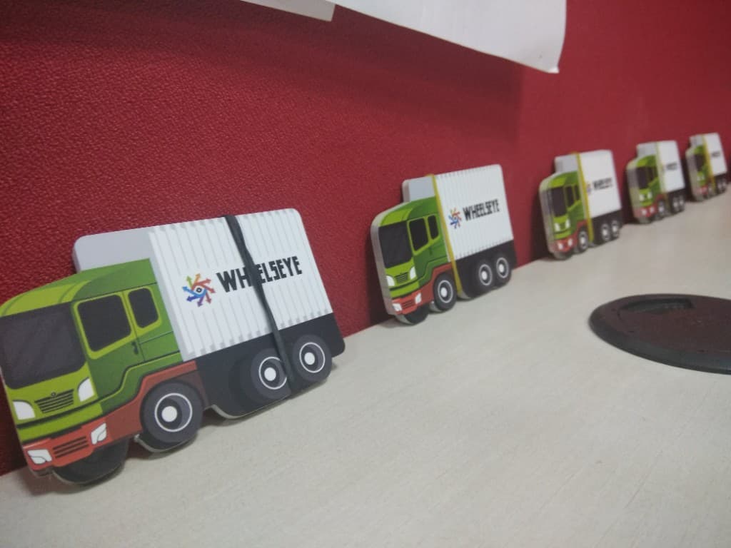 A row of die-cut WheelsEye truck-shaped business cards standing on an office desk