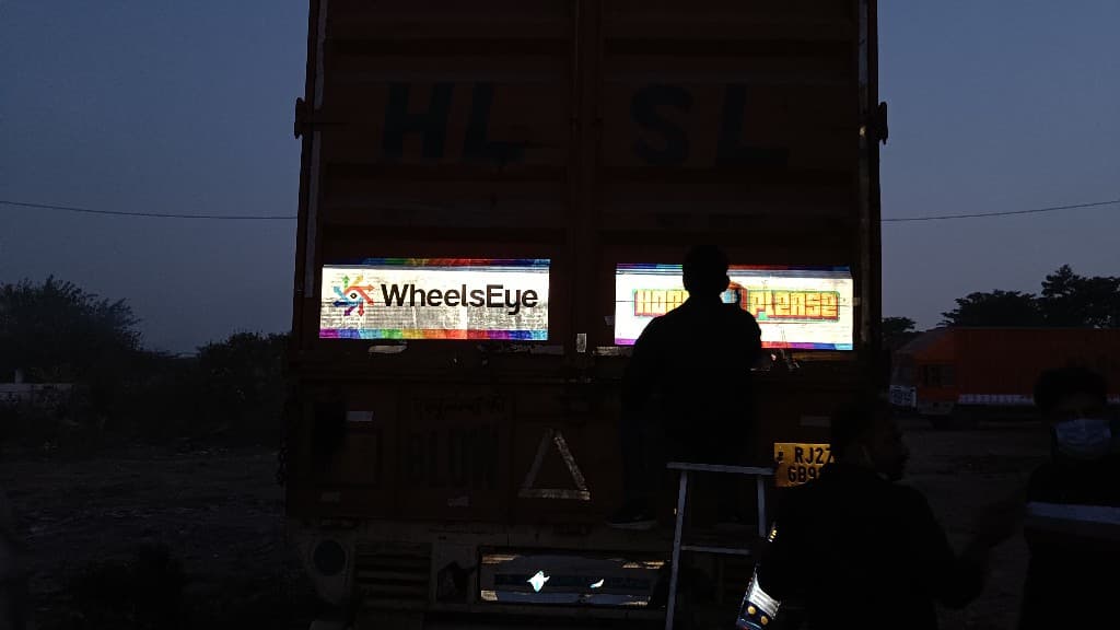 Backlit WheelsEye and Horn Please panels being installed on a truck at dusk