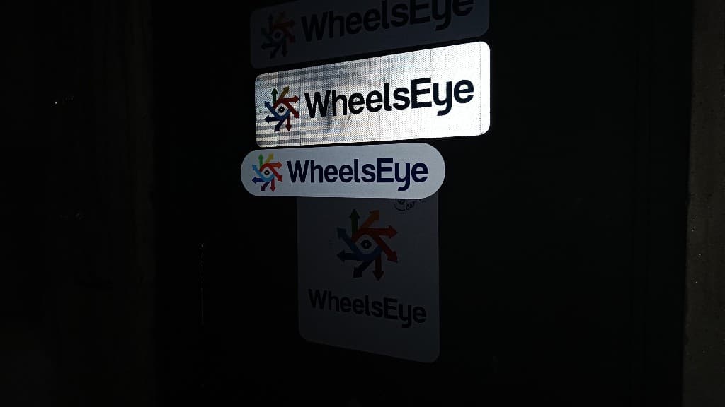 WheelsEye sticker samples pasted on a metal fire door for adhesive testing