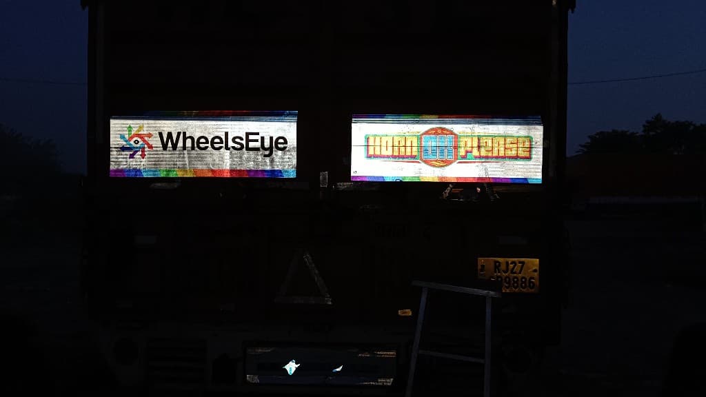 WheelsEye reflective sticker on the back of a truck at night on an Indian highway